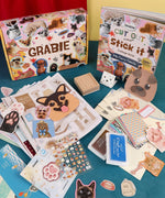 My Furry Family-Themed Grabie Scrapbook Club Box with stickers, paw prints, stamps, and collage supplies for creative scrapbooking.