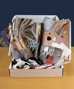 Threads Of Time-Themed Grabie Scrapbook Club Box with vintage papers, buttons, scissors, and art supplies for crafting.
