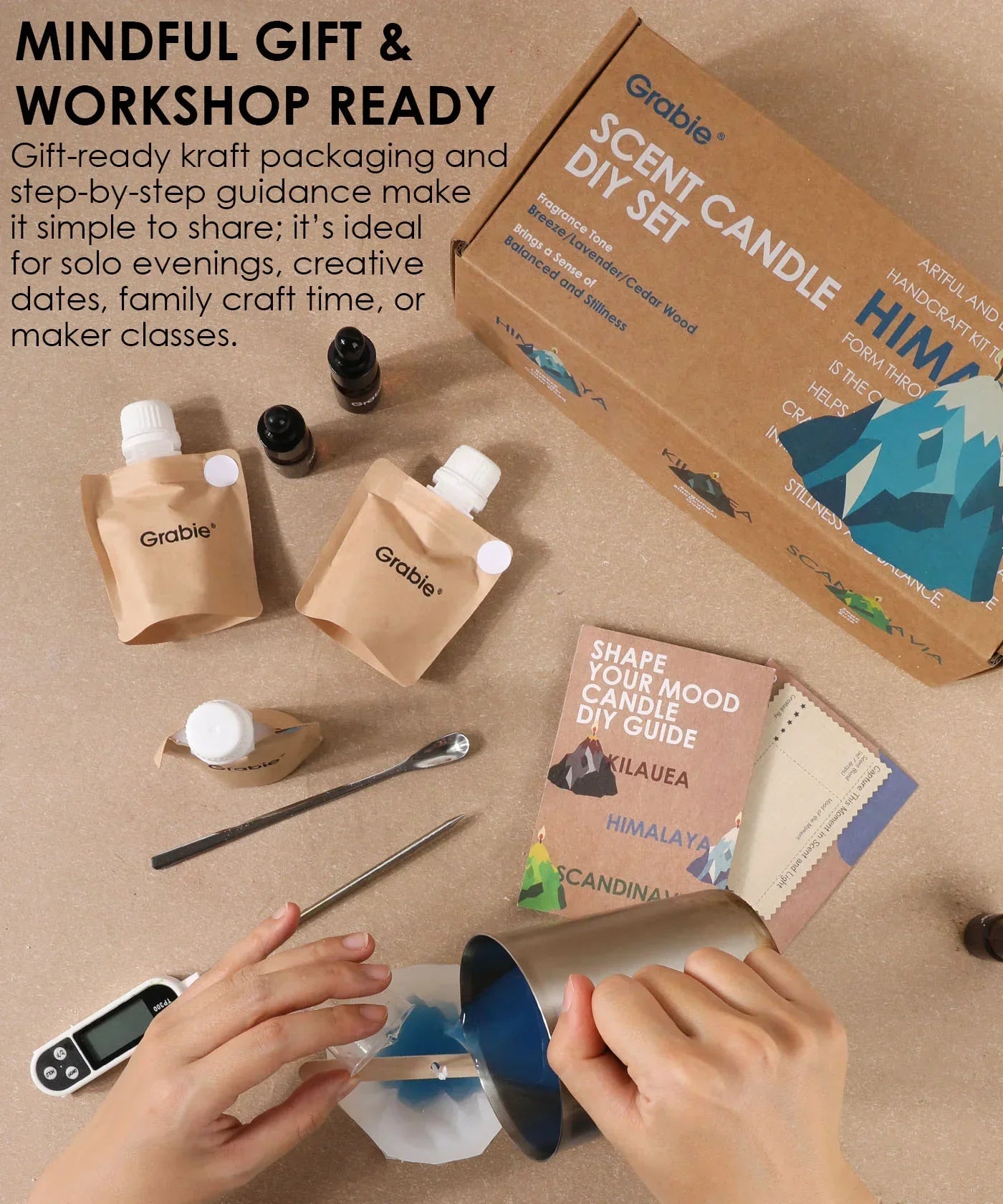 Hands pouring wax into mold with Scent Candle DIY Set kit including packaging, oils, and guide on table