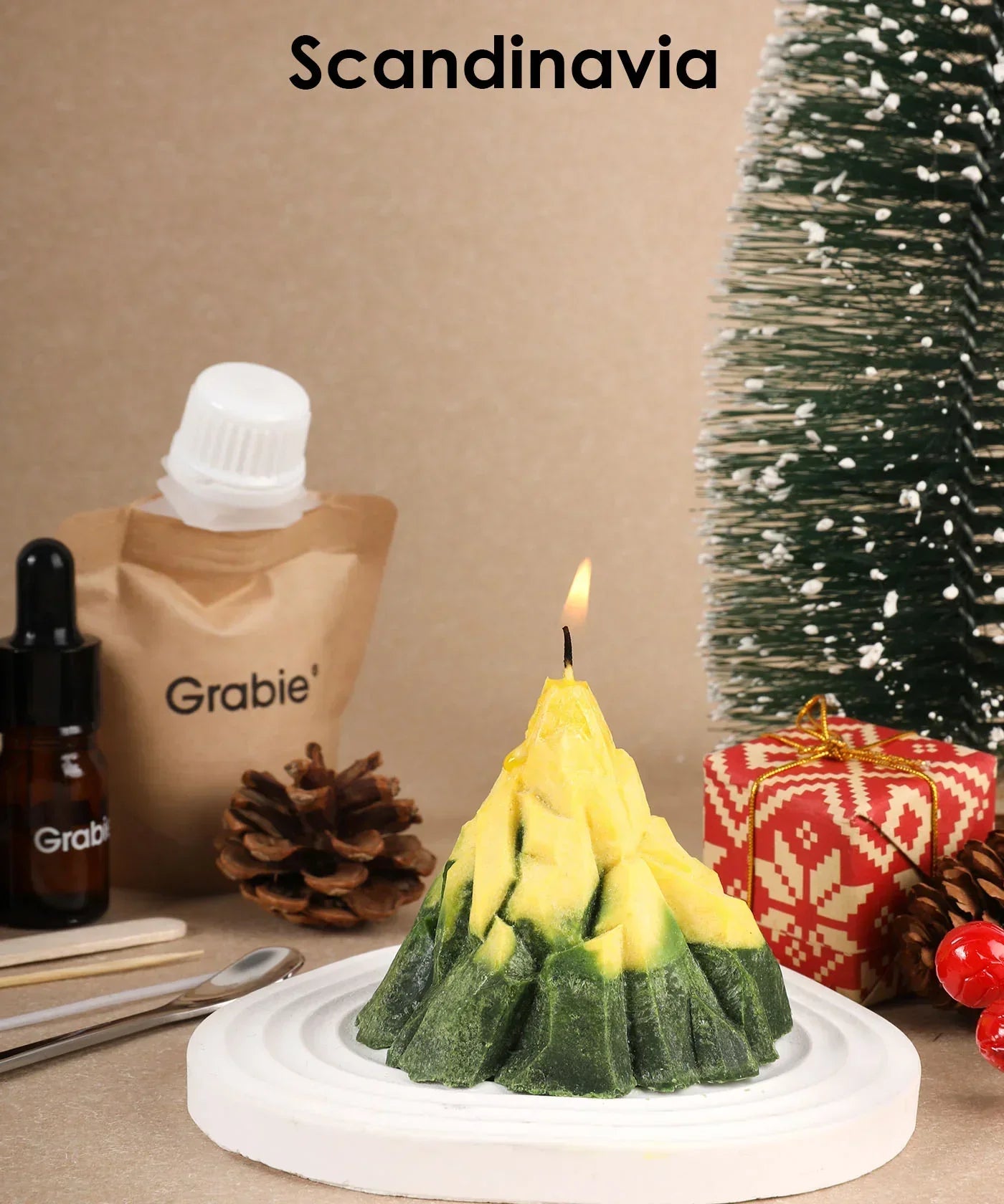 Scent Candle DIY Set featuring a lit mountain-shaped candle with pinecones, gift box, and miniature tree decoration.