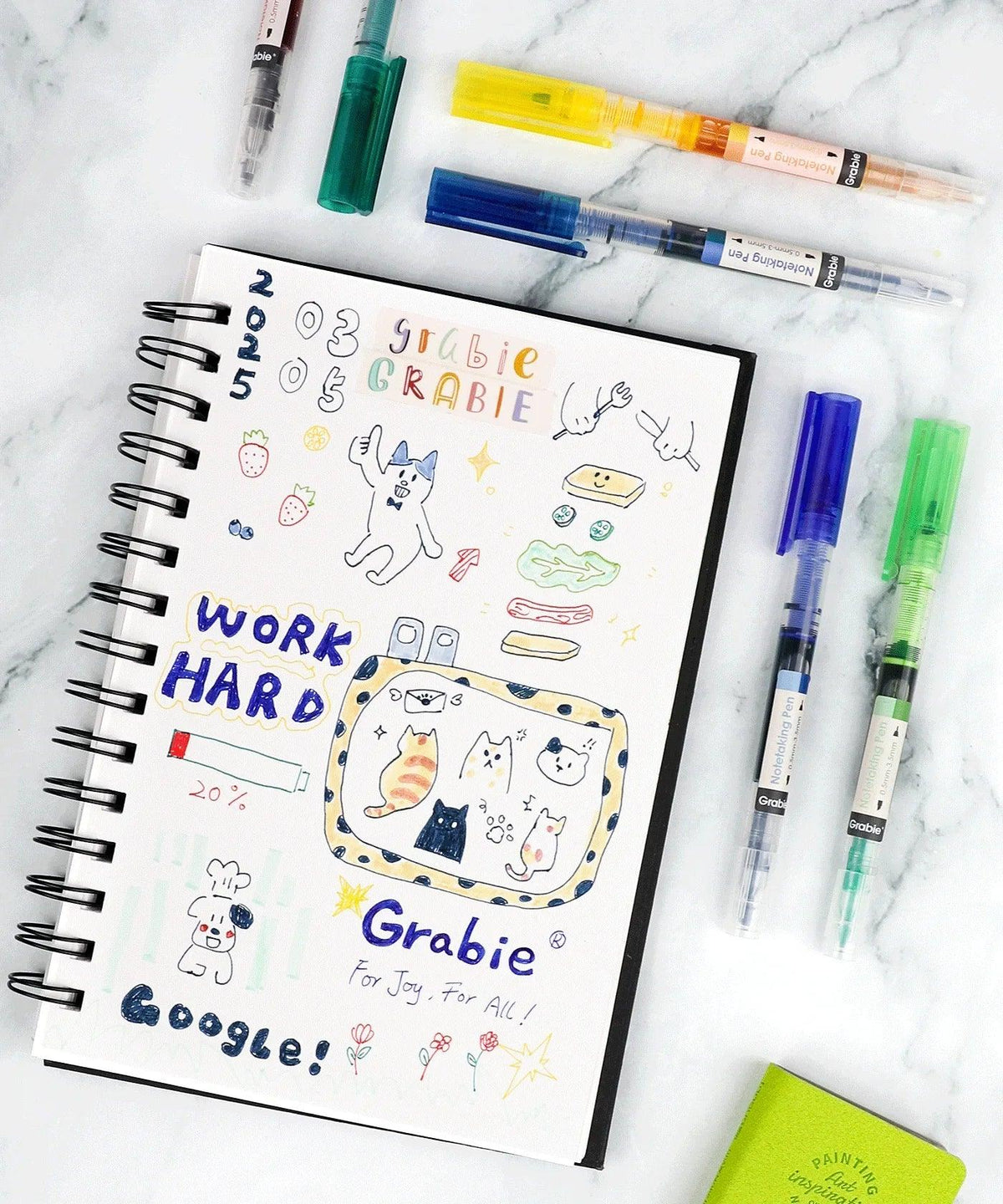 Dual-Tip Notetaking Pen Set Of 6 with colorful drawings and lettering on a sketchbook on white marble background