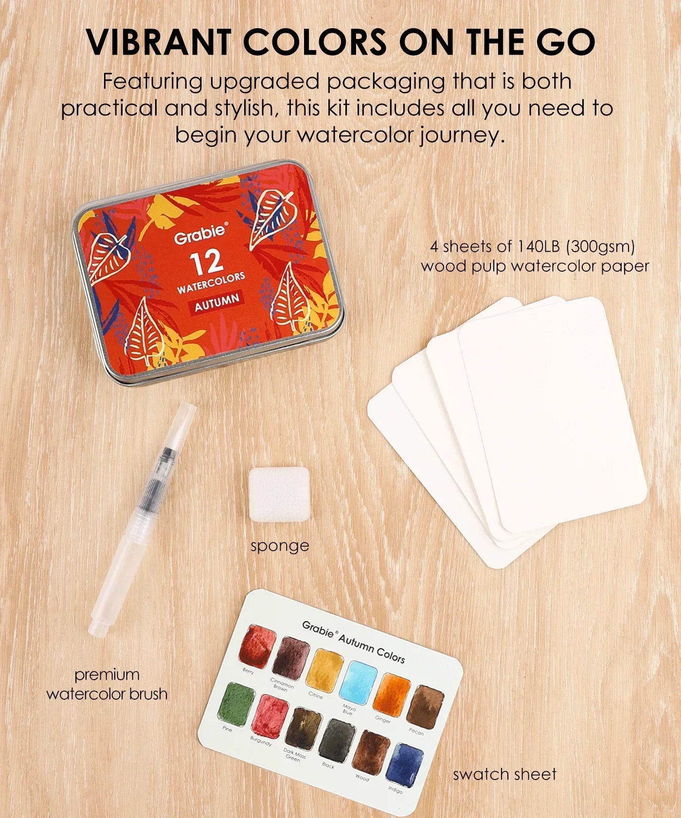 Watercolor Pocket Set Of 12 With Brush - Autumn Colors kit with brush, sponge, swatch sheet, and watercolor paper sheets on wood table