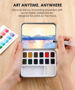 Hands holding and painting with Watercolor Pocket Set Of 12 With Brush - Landscape Colors on wooden surface