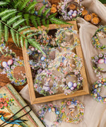 Easter-Themed Grabie Scrapbook Club Box featuring delicate floral wreaths with bunnies and pastel Easter eggs for crafting.