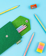 Colorful Inspirational Sketch Pencil Set with pastel pencils in green felt case alongside sharpener and eraser on blue background