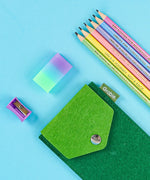 Colorful Inspirational Sketch Pencil Set with pastel pencils, a gradient eraser, sharpener, and green felt pencil case on blue background