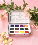 Watercolor Pocket Set of 12 - Floral Colors featuring vibrant floral-inspired watercolor pans in a compact metal tin with soft pink flowers.