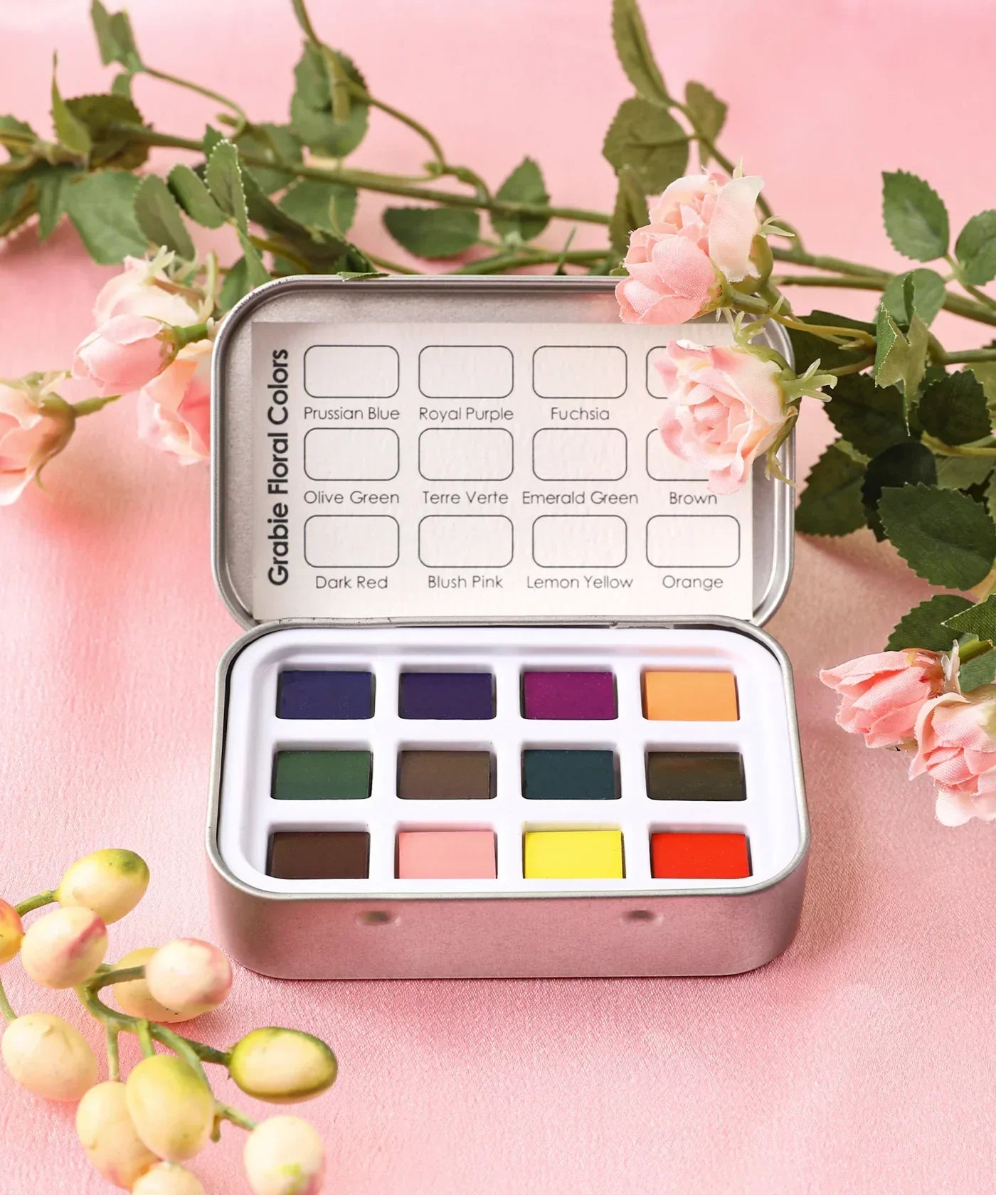 Watercolor Pocket Set of 12 - Floral Colors featuring vibrant floral-inspired watercolor pans in a compact metal tin with soft pink flowers.