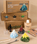 Grabie Scent Candle DIY Set with mountain-shaped candles, fragrance oils, wooden sticks, and instructions on a beige background