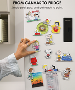 White refrigerator door decorated with colorful DIY cute fridge magnets of Snoopy, Woodstock, and Charlie Brown.