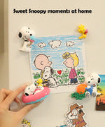 Finished Snoopy and Woodstock painted resin magnets displaying artwork on a refrigerator for DIY home decor.