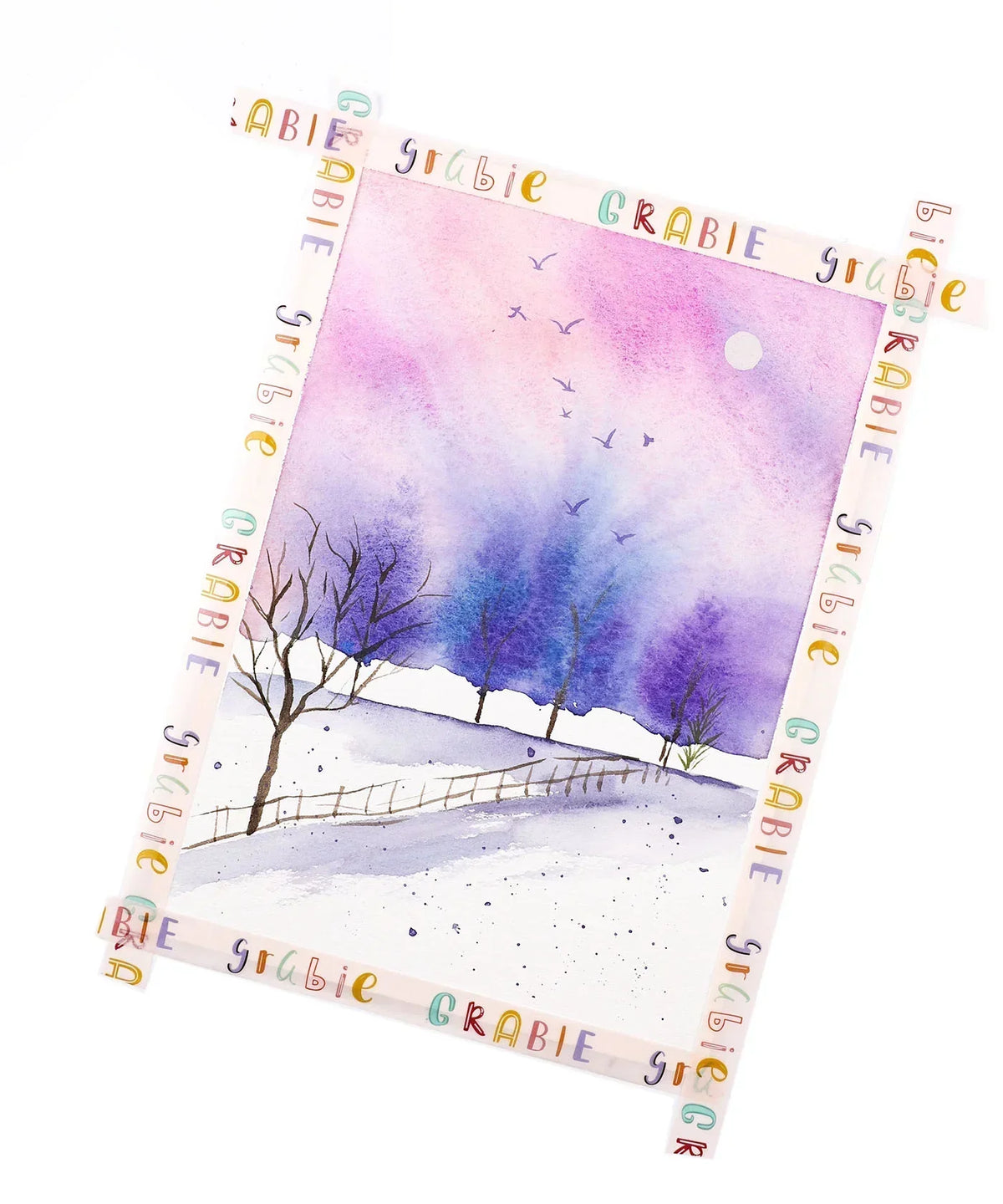 Grabie Waterproof Painter's Tape Set Of 2 securing a watercolor painting of a purple and blue winter landscape with trees and birds.