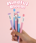 Hand holding a bouquet-like set of 6 Grabie Mindful Bloom novelty pens with blooming flower caps.   