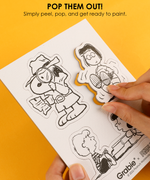 Hand peeling detective Snoopy from the pop-out canvas sheet ready for painting DIY magnets.