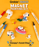 Snoopy and Woodstock resin figures alongside dual tip markers in a DIY craft kit setup.